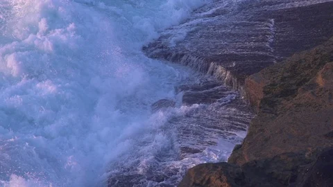 Ocean wave in soft morning light crashing onto rocks in slow motion Stock Footage 107959889