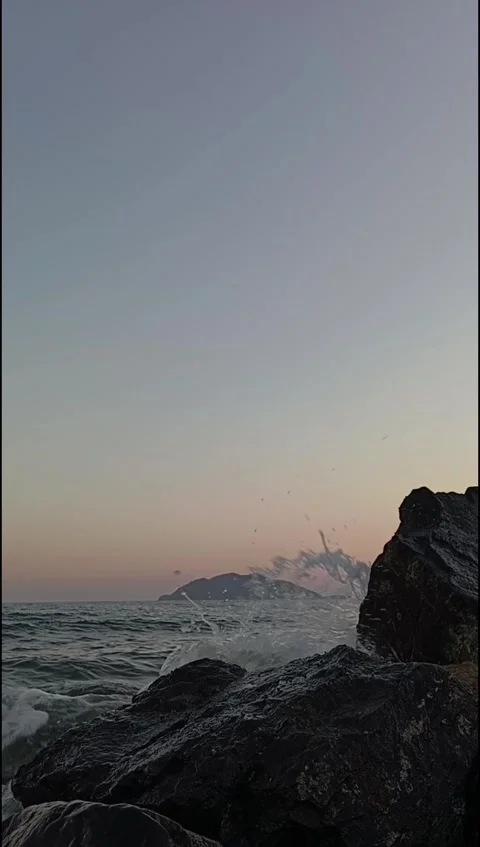 Ocean Wave Splash Against Coastal Rocks at Sunset Stock Footage 338099615