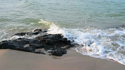 Ocean wave splashes across a big rock in the middle of the rough exotic sea brea Stock Footage 201009290