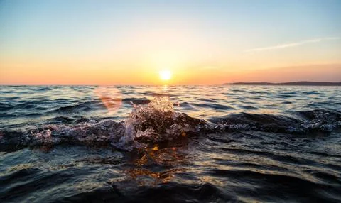 Ocean wave at sunset Stock Photos
