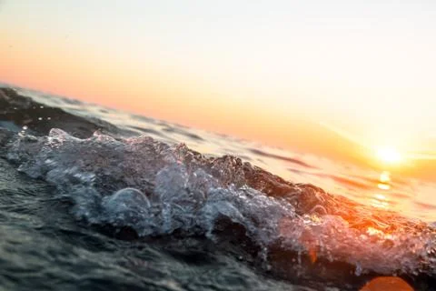 Ocean wave at sunset Stock Photos