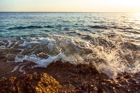 Ocean wave at sunset Stock Photos