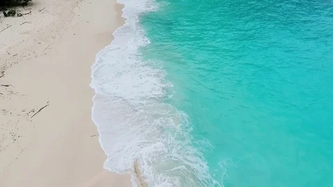 Ocean wave on tropical beach. White sand and crystal-blue sea. Aerial view Stock Footage 85377264
