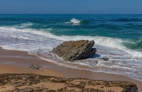 Ocean wave washing over a stone Stock Photos