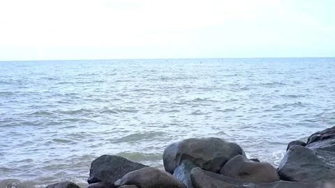 Ocean waves in the afternoon with large rocks in the background Stock Footage 263053874