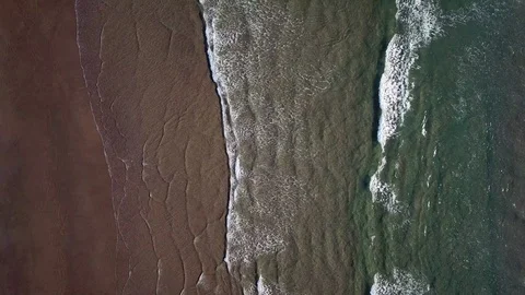 Ocean waves along a sandy beach Stock Footage 87761923