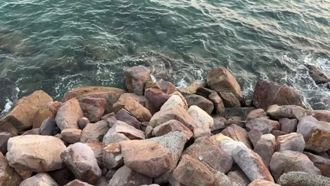 Ocean waves and boulder rock, Water ripples splashing over Видео 342528786