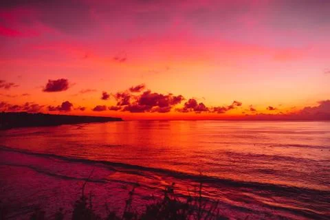Ocean with waves and bright sunset or sunrise in Bali. Ocean with sunset colo Stock Photos