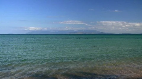 Ocean waves and distant mountains Stock Footage 856227