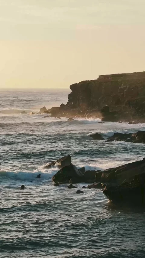 Ocean Waves and Stone Cliffs in Warm Sunset Glow. Stock Footage 327039415