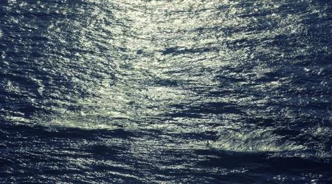 Ocean waves and the water surface at sunset Stock Photos