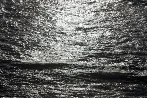 Ocean waves and the water surface at sunset Stock Photos