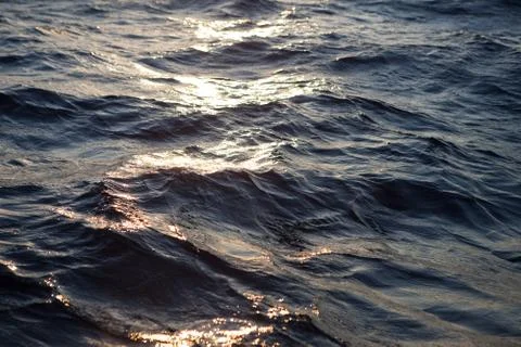 Ocean waves and the water surface at sunset Stock Photos