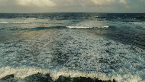 Ocean waves approaching the coast under cloudy sky at sunset in Mexico Stock Footage 312655645