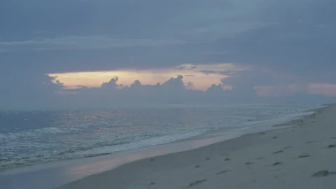 Ocean waves on beach at dusk soft pink sunset with stormy clouds Stock Footage 143979897