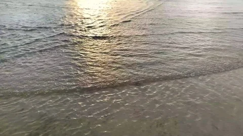 Ocean waves on beach at sunset time, sunlight reflect on water surface Stock Footage 115996982