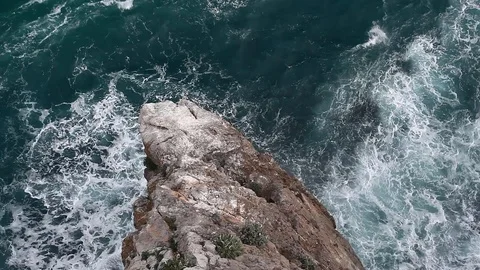 Ocean waves beating against a rock, view from above Stock Footage 120415893