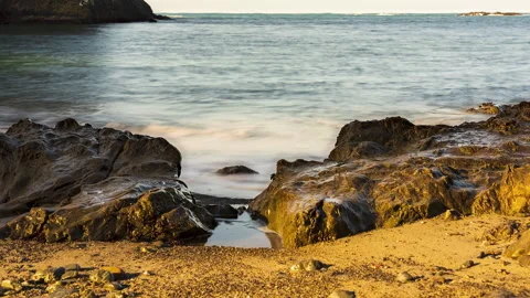 Ocean waves between two rocks on a sandy beach - daytime timelapse Stock-Footage 219763236