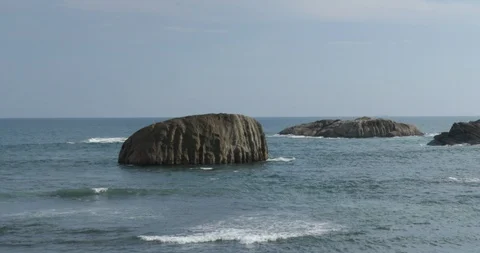 Ocean waves break against the rocks Stock Footage 86954571