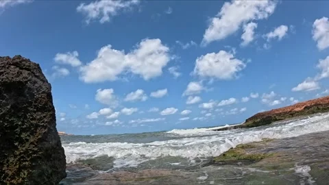 Ocean waves break with force on coastal rocks, slow motion shot with foam a.. Video stock 313612113