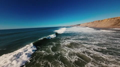 Ocean waves break with white foam near rocky shore Stock Footage 339803716