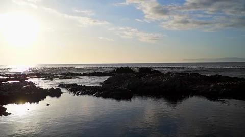 Ocean waves breaking against rocky shoreline at sunset Stock Footage 87279482