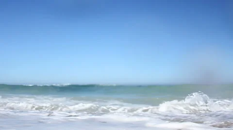 Ocean waves breaking against the shore on a clear blue summer day 動画素材 32936105