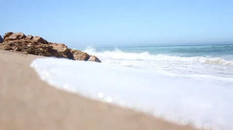 Ocean waves breaking against the shore on a clear blue summer day Vídeos de archivo 32936195
