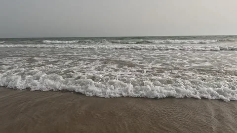 Ocean Waves Breaking on Empty Beach Under Overcast Sky Stock Footage 341465544