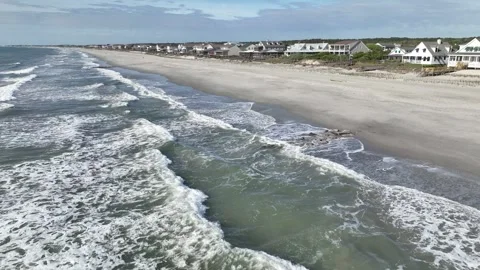 Ocean waves breaking in front of vacation beach houses in Pawleys Island, SC Stock Footage 240159304