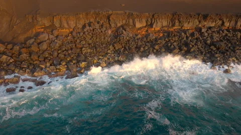 Ocean waves breaking on golden volcanic coastline Stock-Footage 256495877