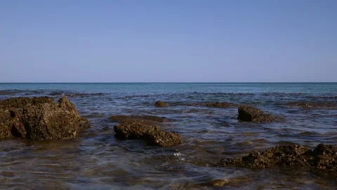 Ocean waves breaking over rocks on beach Video stock 98183130