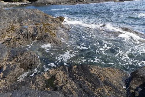 Ocean Waves Breaking Over Rocky Shore with Sea Foam Foto stock