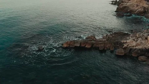 Ocean waves breaking with a rock on the shore of the beach Stock-Footage 163737944