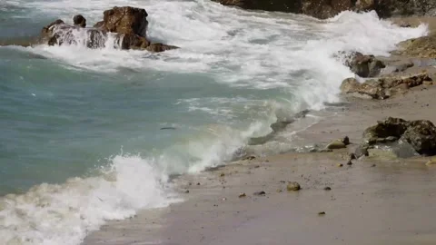 Ocean waves breaking on the rocks and sandy beach Stock Footage 329816578