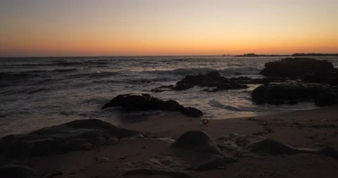 Ocean waves breaking on rocks at the beach after sunset Stock Footage 131895272