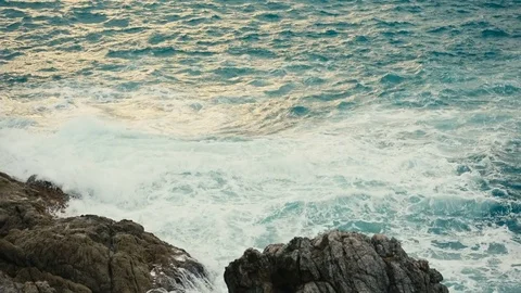 Ocean waves breaking on a rocky shore at sunset Stock-Footage 84140708