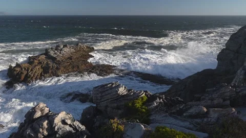 Ocean waves breaking onto the rugged, rocky Hermanus coastline. Stock Footage 306840322
