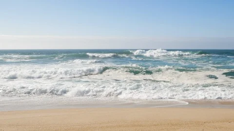 Ocean waves breaking on sandy beach with blue sky Stock Footage 104409248