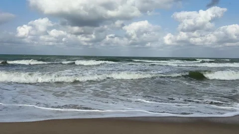 Ocean waves breaking on a sandy beach under a cloudy sky Stock Footage 328336098
