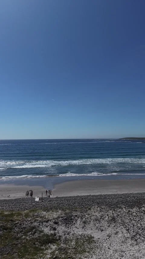 Ocean Waves Breaking on a Sandy Beach Under Clear Blue Sky 動画素材 339582696