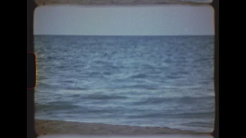 Ocean waves breaking on sandy beach on Super 8 film Stock Footage 344440826