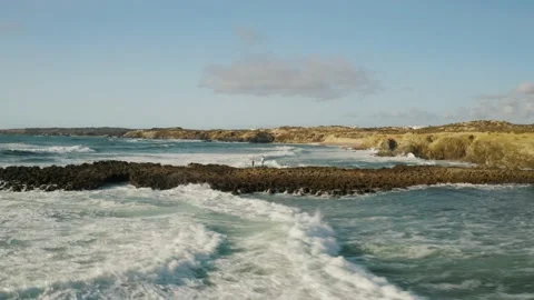Ocean waves breaking on sandy cliffs and rocky shore coastline Stock Footage 142751126