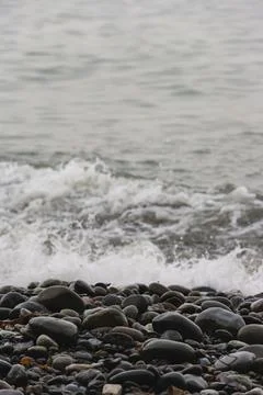 Ocean waves breaking on the shore of smooth beach pebbles, Strait of Juan d.. Stock Photos