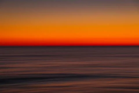 Ocean with waves at bright sunset or sunrise shooting with long exposure Stock Photos