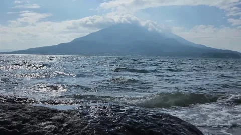 Ocean waves crash against dark, wet shorestones 스톡 동영상 337696819