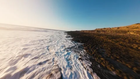 Ocean waves crash against dark, rugged cliffs Stock Footage 339788213