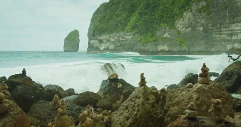 Ocean Waves Crash Against Rocks. Sea waves surge powerfully around a stack of Stock Footage 258854949