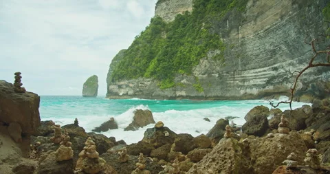 Ocean Waves Crash Against Rocks. Sea waves surge powerfully around a stack of Stock Footage 259479212