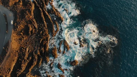 Ocean waves crash against sharp cliffs of shore, drone shot Stock Footage 104069906
